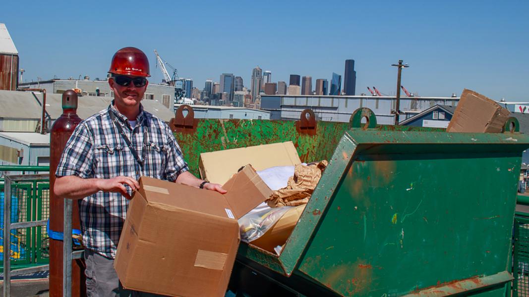 Vigor employee breaks down boxes to go in the recycle bin