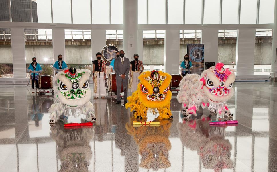 A photo of the Mak Fai Dragon & Lion Dancers presenting their banner to SEA Managing Director Lance Lyttle with CHIKIRI and The School of Taiko in the background.