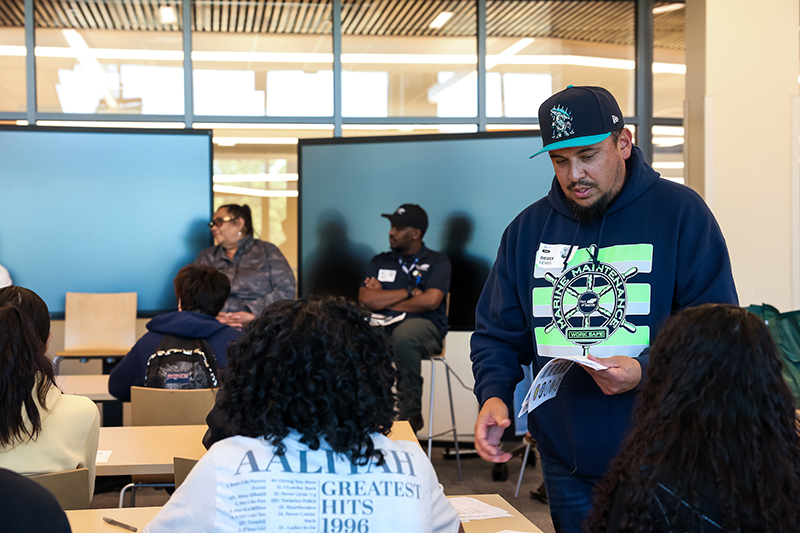 Port employee distributes handout to students.