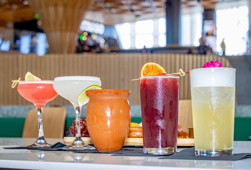 Five fruity cocktails displayed on a table.