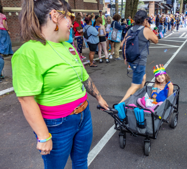 At the Seattle Pride Parade, Commissioner Hasegawa pulls her daughter, Keiko, in a wagon