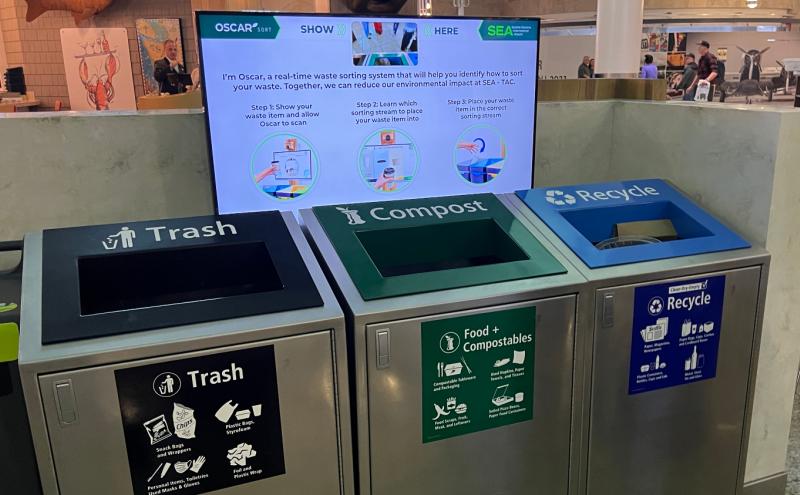 Oscar AI screen above trash, food + compostables, and recycling bins