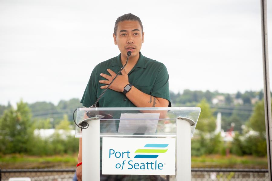 Person speaks at a podium next to a river park