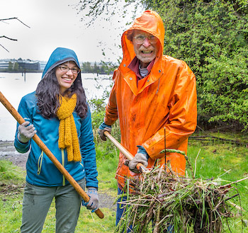 George Blomberg holds up a thick scoop of vegetation at Duwamish Alive