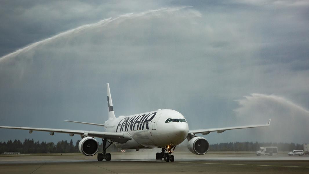 Inaugural Finnair aircraft arriving at SEA Airport under a water turret