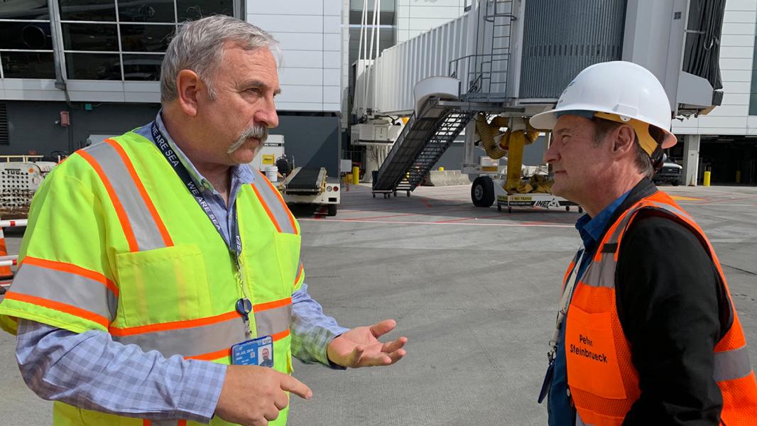 Paul Pelton talks with Commissioner Steinbrueck on the airfield at Sea-Tac Airport