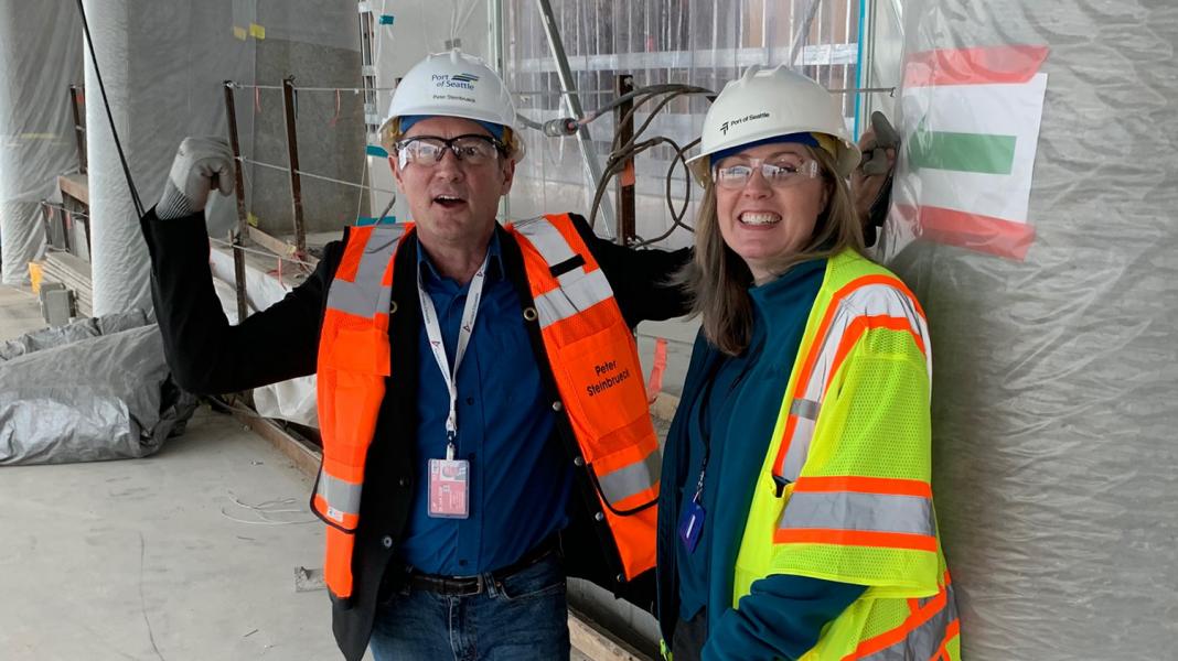 Janet Sheerer and Commissioner Steinbrueck in the new International Arrivals Facility under construction at Sea-Tac Airport, April, 2019