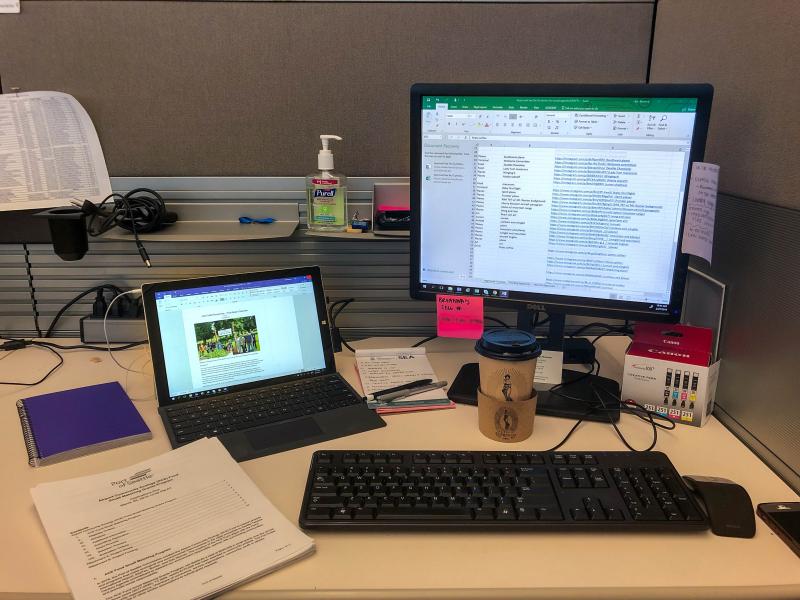 Image of a desk with tools: a computer, notepad