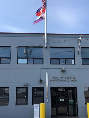 Horton Street facility of Maritime Maintenance with Pride and Juneteenth flags flying above