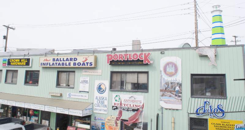 the Side of Pacific Fishermen's Shipyard with signs from old Ballard institutions