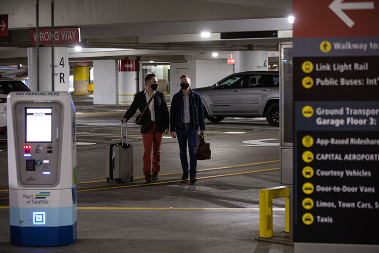 Masked passengers walking through SEA Airport parking garage