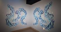 Abstract blue and teal mural with flowing, wave‑like shapes on two intersecting walls.