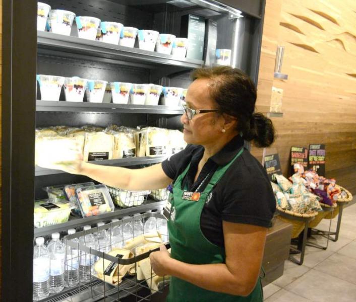 Starbucks employee clears out the food case to donate to food banks