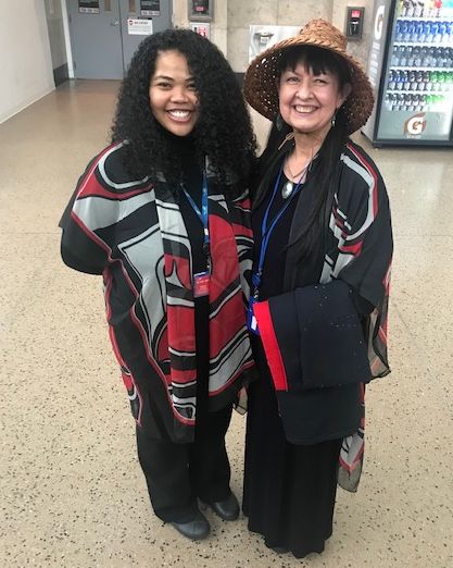 Two women dressed in Native outfits at SEA Airport