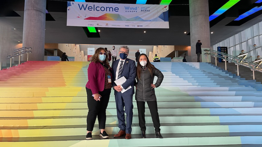 Commissioner Hasegawa, Commissioner Felleman, and Commission Strategic Advisor LeeAnne Schirato at the entrance of the 2022 Wind Europe Conference in Bilbao, Spain.