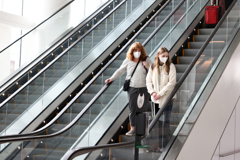 Two women in masks on the escalator