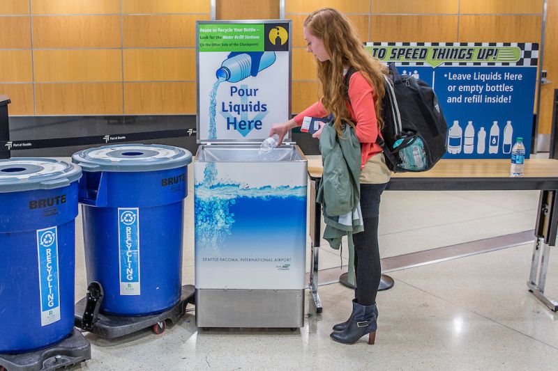 Passenger pours out her liquids before entering the security checkpoint