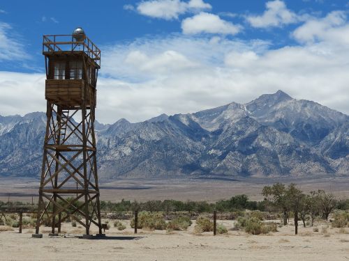 Manzanar guard tower with barbed wire and mountains