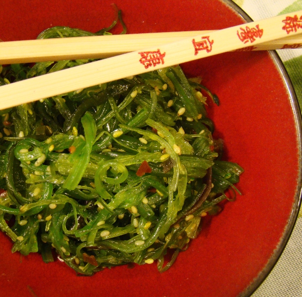 Seaweed salad on a plate with chopsticks
