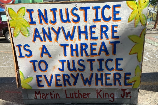 sign that says Injustice Anywyhere Is a Threat to Justice Everywhere