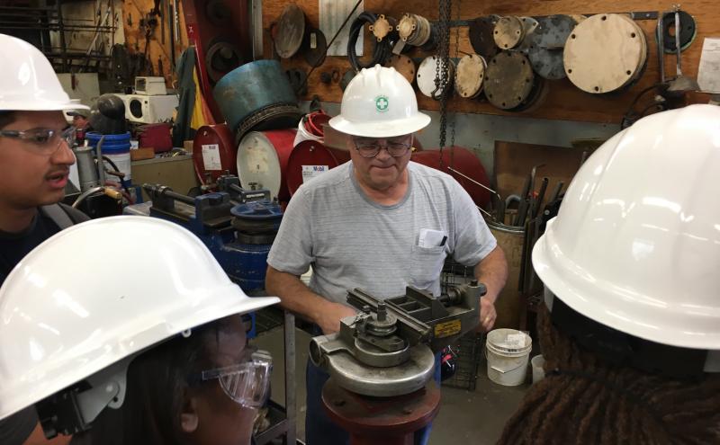 People in hard hats working in a maritime industrial site. 
