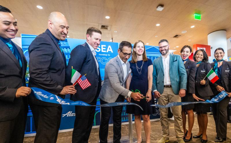 Representatives from Alaska Airlines and the Port of Seattle pose for a photo and ribbon cutting at the inaugural gate event, celebrating the new nonstop flight from Seattle to Rome.