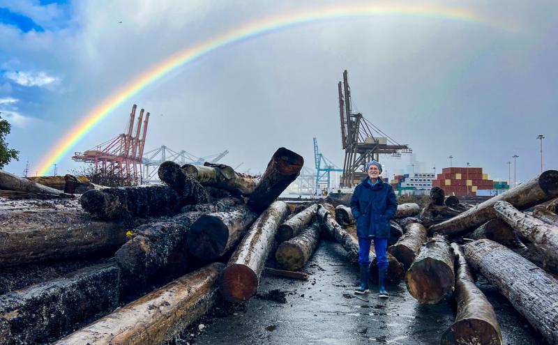 George Blomberg at a Port habitat restoration site with a cargo terminal and rainbow backdrop