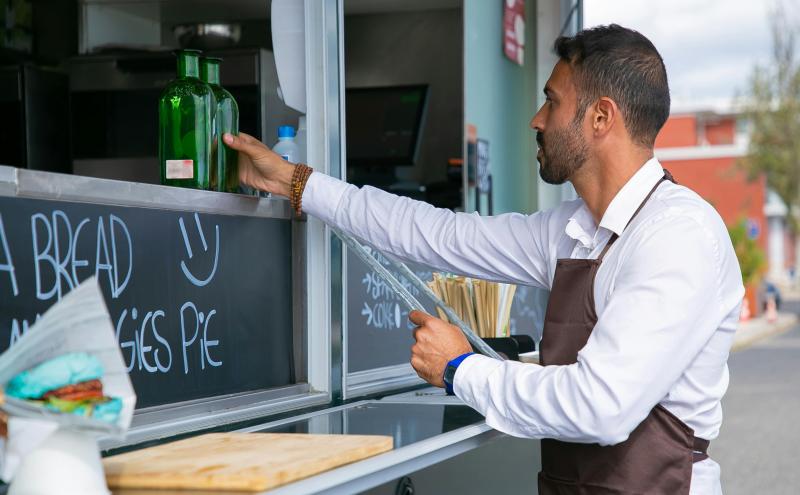 Food Truck owner putting bottles on display outside food truck