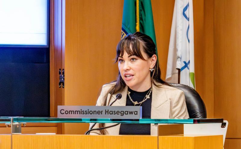 Commissioner Hasegawa behind the podium at a Commission meeting.