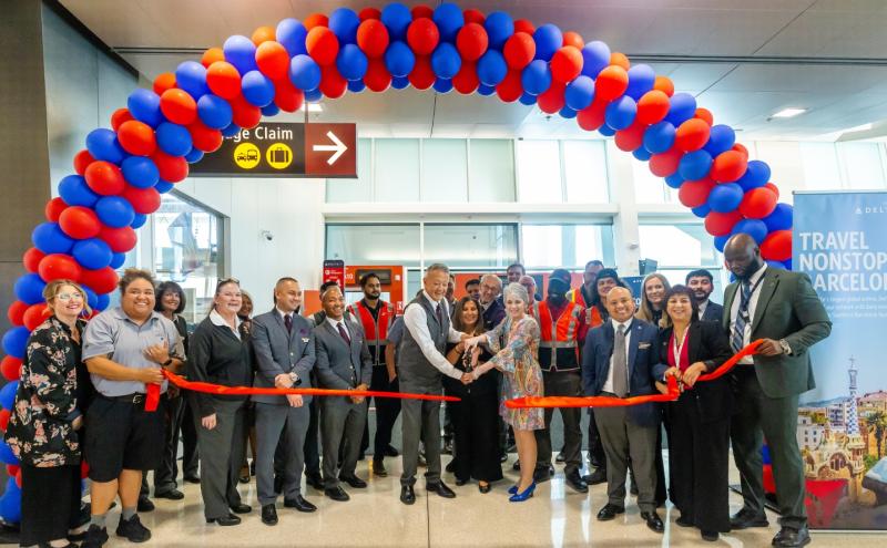 Arch of balloons with people cutting the ribbon to launch two new Delta flights at SEA Airport 