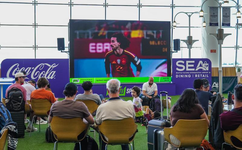 Travelers watching a soccer match