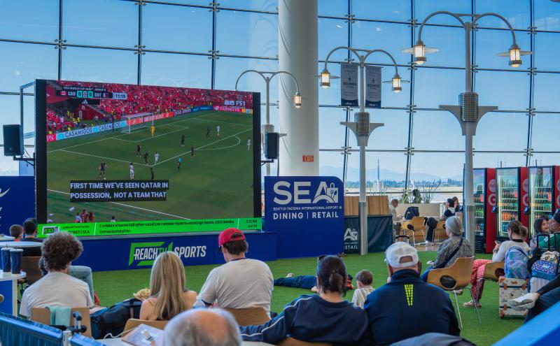 Travelers watching a soccer match