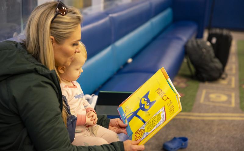 Parent and infant read a picture book in the children's play area