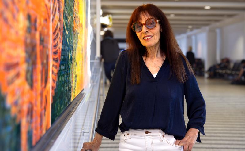 Artist poses next to her work at the D3 restrooms 