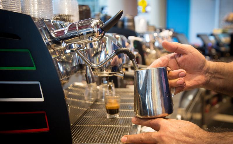 Barista steams milk at Caffe D'arte