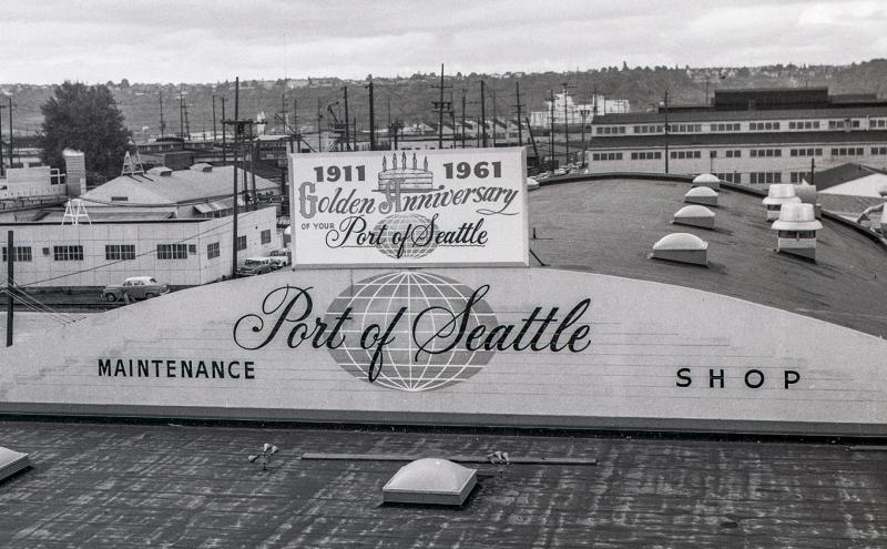 Historic photo of the Port of Seattle’s Marine Maintenance building with signage indicating the Port’s anniversary in 1961.