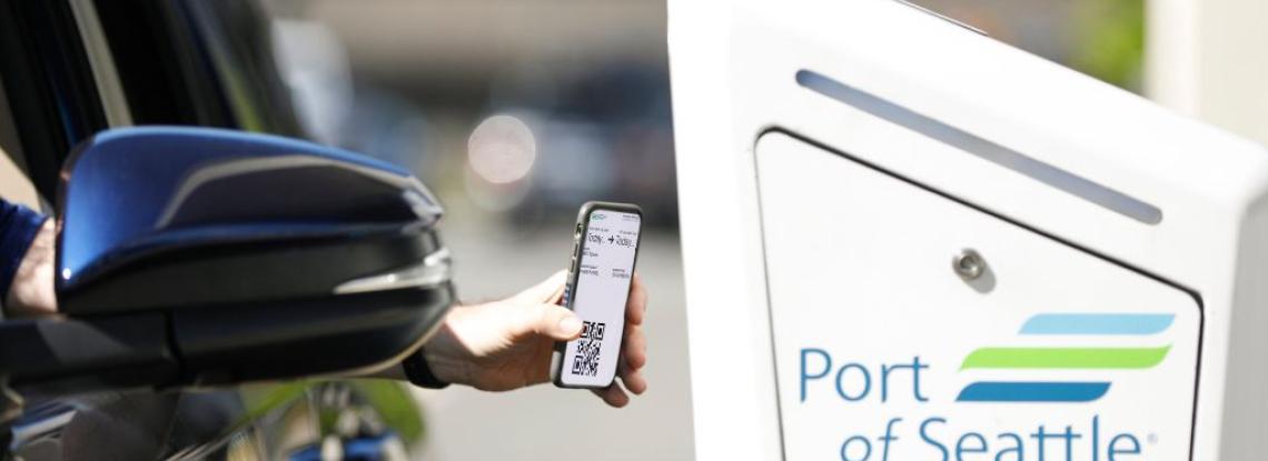 Person scanning cell phone to enter parking garage.