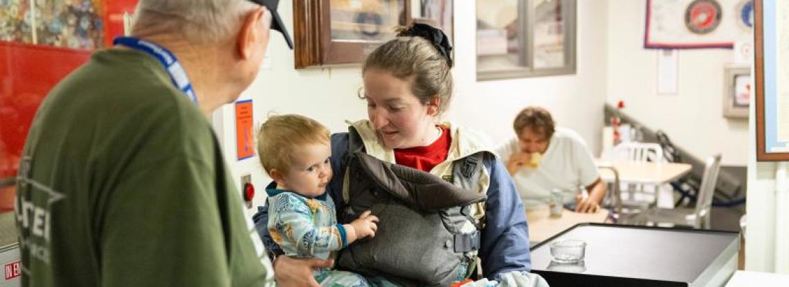 Woman holding a baby in the SEA Airport USO