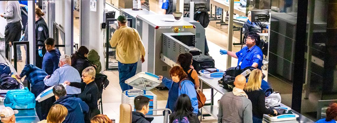Travelers go through TSA screening at SEA.