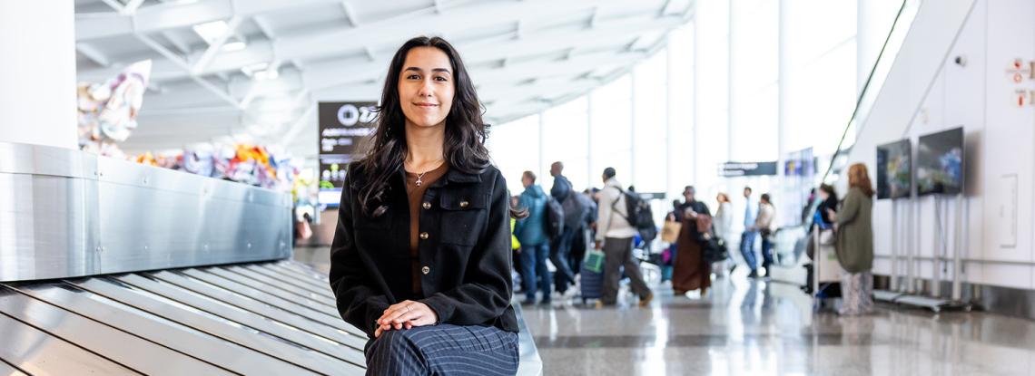 Cilicia Diaz poses by the baggage carousel in the International Arrivals Facility.