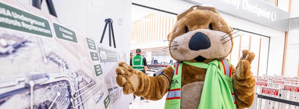 Jett the SEA Otter poses by the Upgrade SEA projects map.