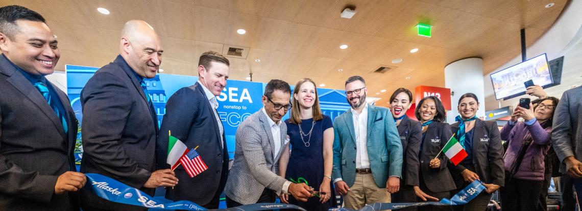 Representatives from Alaska Airlines and the Port of Seattle pose for a photo and ribbon cutting at the inaugural gate event, celebrating the new nonstop flight from Seattle to Rome.