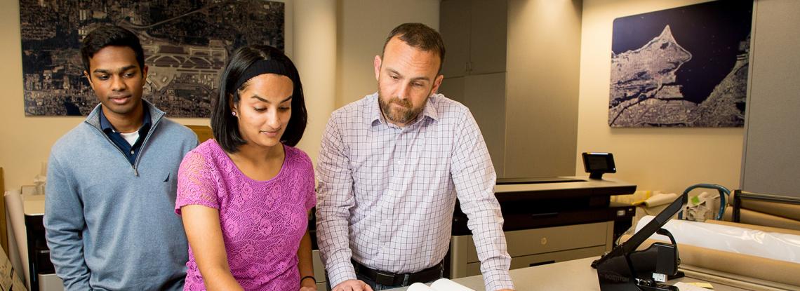A group of employees reviews plans.