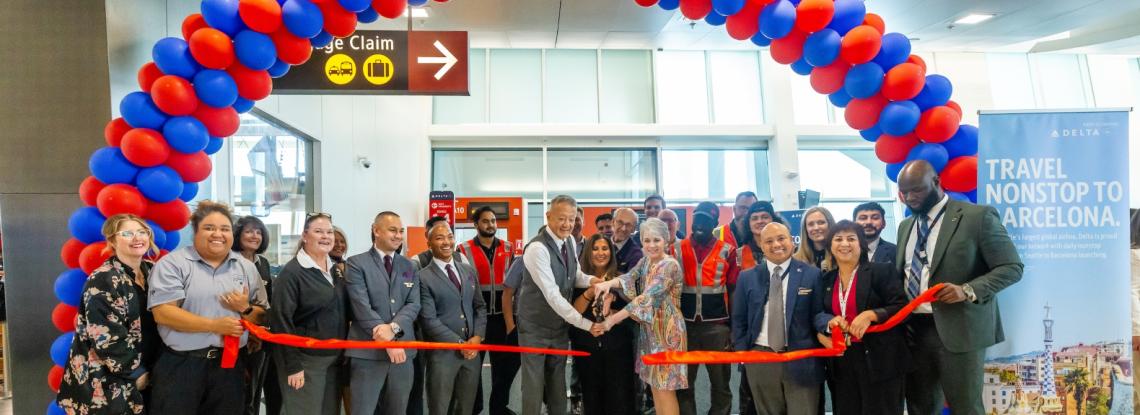 Arch of balloons and people cutting the ribbon to welcome two new Delta flights to SEA Airport 