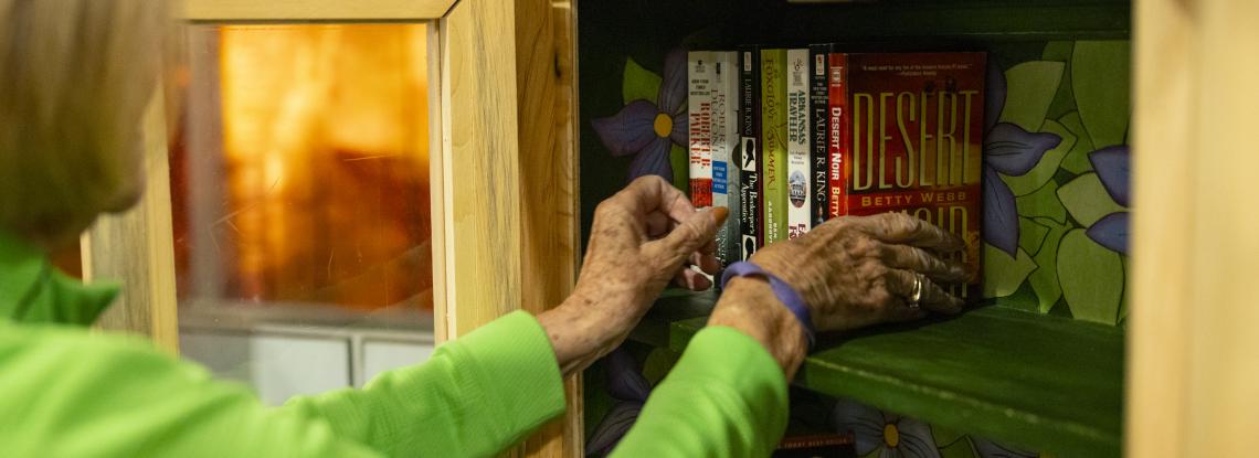 Little Free Library volunteer restocks the library 