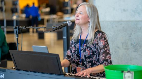 Cami Voss smiling and playing the piano at Central Terminal. 