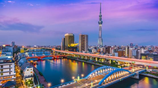 The colors of sunset off Tokyo's Sumida River highlight the art deco blue arches of Komagata Bridge, 2,080-foot-tall Tokyo Skytree building, and the golden Asahi Building.