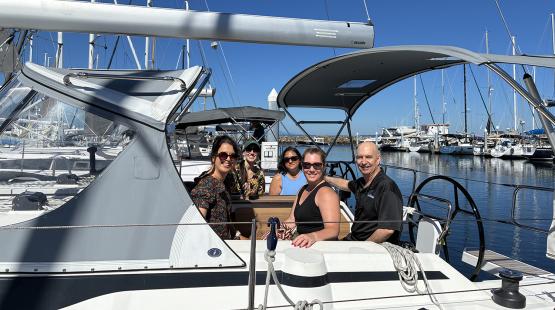 Captain and four passengers pose for a photo before a chartered sail boat cruise with Windworks Sailing and Powerboating
