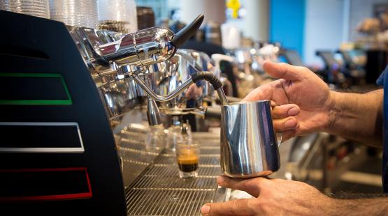 Barista steams milk at Caffe D'arte