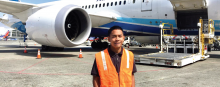 Headshot of Ronnie Estoque in front of a parked airplane